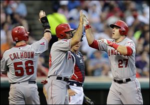 Los Angeles Angels' Mike Trout (27) celebrates his three-run home run with Raul Ibanez and Kole Calhoun (56) in the fifth inning.