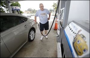 Marty Mascio, of Pembroke Pines, Fla., pumps gasoline into his car at a Chevron gasoline station in Pembroke Pines, Fla. Gasoline prices increased 0.7 percent last month.