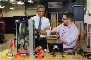President Obama listens as Andy Leer demonstrates how a 3D printer works during a visit to TechShop Pittsburgh in Bakery Square. The President was in Pittsburgh on Tuesday to speak about spurring innovation by opening local and federal facilities to entrepreneurs.
