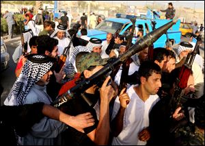 Iraqi Shiite tribal fighters raise their weapons and chant slogans against the al-Qaeda-inspired Islamic State of Iraq and the Levant, after authorities urged Iraqis to help battle insurgents, in Baghdad's Sadr city, Iraq.
