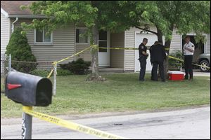 Police and investigators work inside 12313 Washington St. in Perrysburg Heights where a body was found earlier Wednesday.