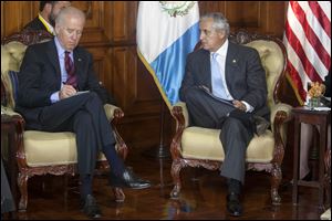 U.S. Vice President Joe Biden, left, writes as Guatemala's President Otto Perez Molina looks on.