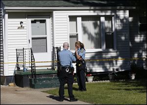 Toledo Police officers secure the home of Thomas Przybysz, 30, in Point Place, after he was stabbed to death on May 23.