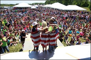 From left, Lisa Vulpitta, Marina Kahl, John Kahl and Randy Lear model their America themed Duck Tape dresses to the crowd during the Duck Tape fashion show at the 11th annual Duck Tape Festival on June 14 at Veterans Memorial Park in Avon, Ohio.