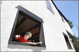Michael Wieser works on a window frame at Dee and Roy Jones’ house during a stop by the Fuller Center’s cyclists. Mr. Wieser is one of 38 bicyclists participating.