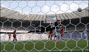 Argentina's Lionel Messi, back left, scores the opening goal past Iran's goalkeeper Alireza Haghighi during the group F World Cup soccer match today at the Mineirao Stadium in Belo Horizonte, Brazil.