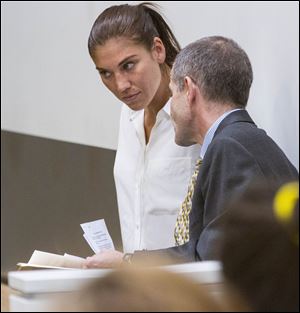 U.S. women's soccer team goalkeeper Hope Solo listens to her attorney Todd Maybrown in Kirkland Municipal Court today in Kirkland, Wash. 