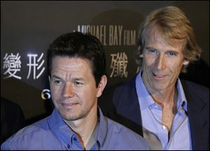 Mark Wahlberg and director Michael Bay pose before a news conference for ‘‍Transformers 4: Age of Extinction’ on Friday in Hong Kong.
