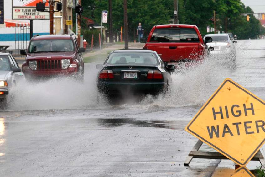 Cars-warned-by-signs-put-up-by-city-workers-slowly-drCTY-flood25p