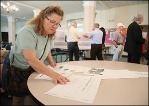 Mary Weil, who lives on Glenwood Avenue, looks over plans at a meeting about rebuilding Bancroft Street between Ashland Avenue and Maplewood Avenue and resurfacing between Maplewood and Monroe Street.