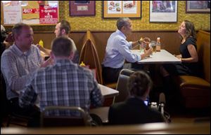 President Barack Obama sits down to have lunch with Rebekah Erler today at Matt's Bar in Minneapolis, Minn. Erler wrote the White House about her struggles to make ends meet.