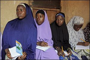 Maimuna Abdullahi, left, listens during class as she and others attend school in Kaduna, Nigeria. Maimuna is one of thousands of divorced girls in Nigeria who were married as children and then got thrown out by their husbands or simply fled. 