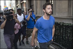 Actor Shia LaBeouf walks through the media after leaving Midtown Community Court following his arrest the previous day for yelling obscenities at a Broadway performance of 
