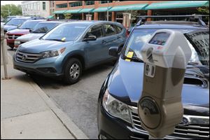 Yellow tickets are visible on  a line of parked cars on Superior near Madison. Toledo has more than 110,000 unpaid tickets — mostly from downtown meters —written in the last dozen years.