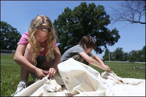 Amelia Fowler, 8, left, and Gage Winebernner, 10, right, work together to put up a canvas tent during a historical lesson of life in the 1794 military.