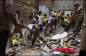 Rescue workers clear debris at the site of a building collapse today in New Delhi, India.