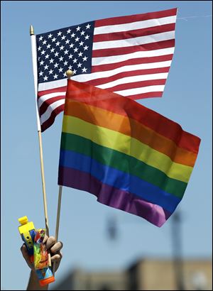 A participant hold flags at the 45th Annual Chicago Pride Parade during Sunday's parade on Broadway Street in Chicago. Gay pride parades stepped off around the nation on Sunday, in cities large and small, with gay, lesbian, bisexual and transgender people and their supporters celebrating a year of same-sex marriage victories.