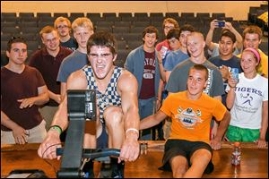 Bailey O’Brien, 18, center left, finishes the final minute of rowing during a world record breaking, 48-hour session with himself and James Miller, 17, right, Sunday at St. John’s Jesuit Academy.