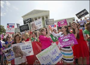 Demonstrator react to hearing the Supreme Court's decision on the Hobby Lobby case outside the Supreme Court in Washington, today.