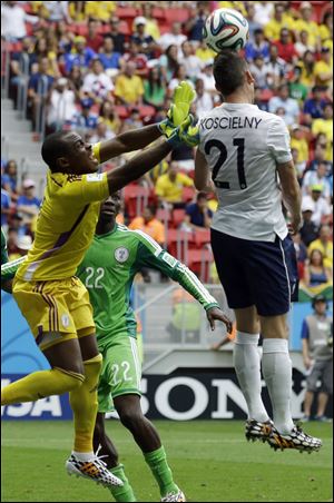 Nigeria's goalkeeper Vincent Enyeama, left, rushes in to defend a header by France's Laurent Koscielny today at the Estadio Nacional in Brasilia, Brazil.