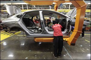Assembly line workers build a 2015 Chrysler 200 automobile at the Sterling Heights Assembly Plant in Sterling Heights, Mich.