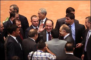 Iraqi Prime Minister Nouri al-Maliki, center, greets lawmakers at the first session of the newly elected parliament today.