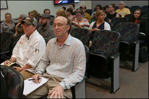 Phil Barone, owner of Rosie’s Italian Grille in Springfield Township, center, and supporters attend a Toledo City Council meeting held to discuss regulations for food truck vendors.