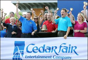 Cedar Fair CEO Matt Ouimet, center, rings the closing bell on the daily session of the New York Stock Exchange Wednesday, at Cedar Point in Sandusky, Ohio. To his left are CFO Brian Witherow and Shannon Rochford of the NYSE. At Mr. Ouimet's right is COO Richard Zimmerman and VP Stacy Frole.