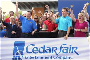 Cedar Fair CEO Matt Ouimet, center, rings the closing bell on the daily session of the New York Stock Exchange Wednesday at Cedar Point. To his left are CFO Brian Witherow and Shannon Rochford of the NYSE. At Mr. Ouimet's right is COO Richard Zimmerman and VP Stacy Frole.