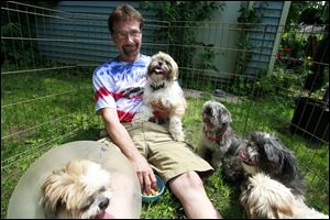George Francel sits with all five Shih Tzus that were returned to him.