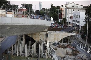 A woker walks up a ladder on a bridge that collapsed in Belo Horizonte, Brazil, Thursday.