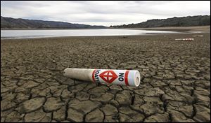 A warning buoy sits on the dry, cracked bed of Lake Mendocino near Ukiah, Calif. Com­pe­ti­tion for wa­ter in Cal­i­for­nia is height­ened by the state’s ge­og­ra­phy: The north has the wa­ter re­sources, but the big­gest wa­ter con­sum­ers are to the south.