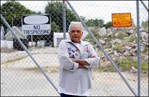 K. LaVerne Redden stands in front of a dump on the corner of London Square and Grand Ave. near Detroit Ave.