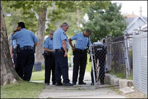 Officers investigate a site on the 600 block of Fernwood Avenue near Wells Street as they look for clues in the wounding of a man on Sunday.