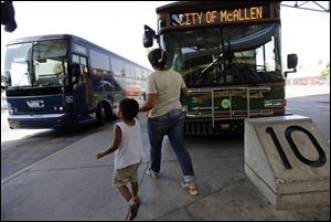 Cindy Jimenez, 26, of Olancho, Honduras, and her son depart the bus station in McAllen, Texas. Jimenez crossed illegally into the U.S.