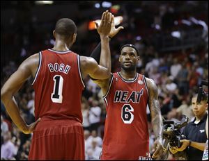 Miami Heat's Chris Bosh (1) and LeBron James (6) celebrate an overtime win against the Sacramento Kings, in Miami. during last NBA season. 