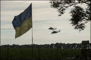 Two Ukrainian military helicopters carry Ukrainian President Petro Poroshenko and Minister of Defense Valery Heletey to inspect weapons captured from rebels at the base in Devhenke village, Kharkiv region, eastern Ukraine.