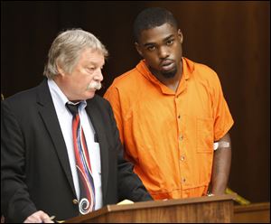 Jerold Riley (also known as Jerold Evans), 19, is arraigned in Toledo Municipal Court, today. Public defender James MacHarg is at left. 