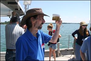 Rick Stumpf, NOAA oceanographer and lead researcher of its algae forecast, looks at a Lake Erie water sample near Put-in-Bay.