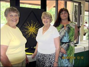 JoAnne Searle, left, was chairman of the Garden Club Forum flower show judges and Mary Alice Shirk and Sylvia Meiring served as student judges. The design in the background by Ms. Searle won a blue ribbon.