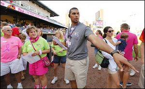 Chris Wormley, a defensive end on the Michigan football team and a Whitmer graduate, gets first pitch participants lined up as he works as a promotions intern with the Toledo Mud Hens.