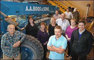 Owners Robert, left, and Charles Boos, center, stand with several of their employees at the headquarters of their business, AA Boos & Sons Construction in Oregon. As of January, the contracting firm employs 160 people full-time, year-round. 