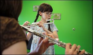 Lucy Morse, 8, takes flute lessons from Amy Heritage of the Toledo Symphony on June 19 at the Toledo Symphony Space.