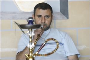 Imad Marouf smokes a lemon and mint hookah in his specialty shop called Hookah Mocha in Monroe, Michigan on April 21, 2010.
