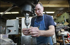 Machinist Paul Hinterberg cleans up burrs from a hinge at Quality Tool & Die in West Allis, Wis. The firm lets employees set their own hours as long as they work a full week and all tasks are completed.