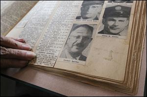 A relative of Toledo Firefighter Ueckert Sperber points out his picture in a news clipping. 