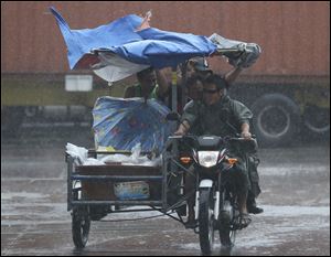 Workers at a nearby fishing port brave strong rains as Typhoon Rammasun batters suburban Navotas, north of Manila,  Philippines.