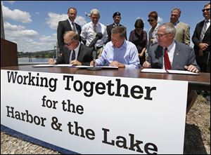 Paul Toth, president of the Toledo-Lucas County Port Authority, left, Ohio Governor John Kasich, and Toledo Mayor D. Michael Collins, sign a proclamation supporting an innovative new dredging strategy for the Toledo Harbor during an event today at IRONHEAD Marine, Inc. on Front Street in Toledo. 