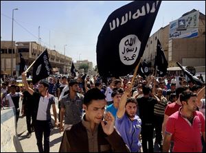 Demonstrators chant pro-Islamic State group slogans as they carry the group's flags in front of the provincial government headquarters in Mosul, 225 miles northwest of Baghdad.