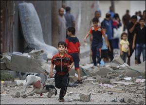 A Palestinian child runs on debris from a destroyed house, following an overnight Israeli strike today in Beit Lahiya, in northern Gaza strip.